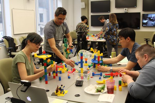 An image showing a group of four people participating in a Create-a-Thon, using building toys.